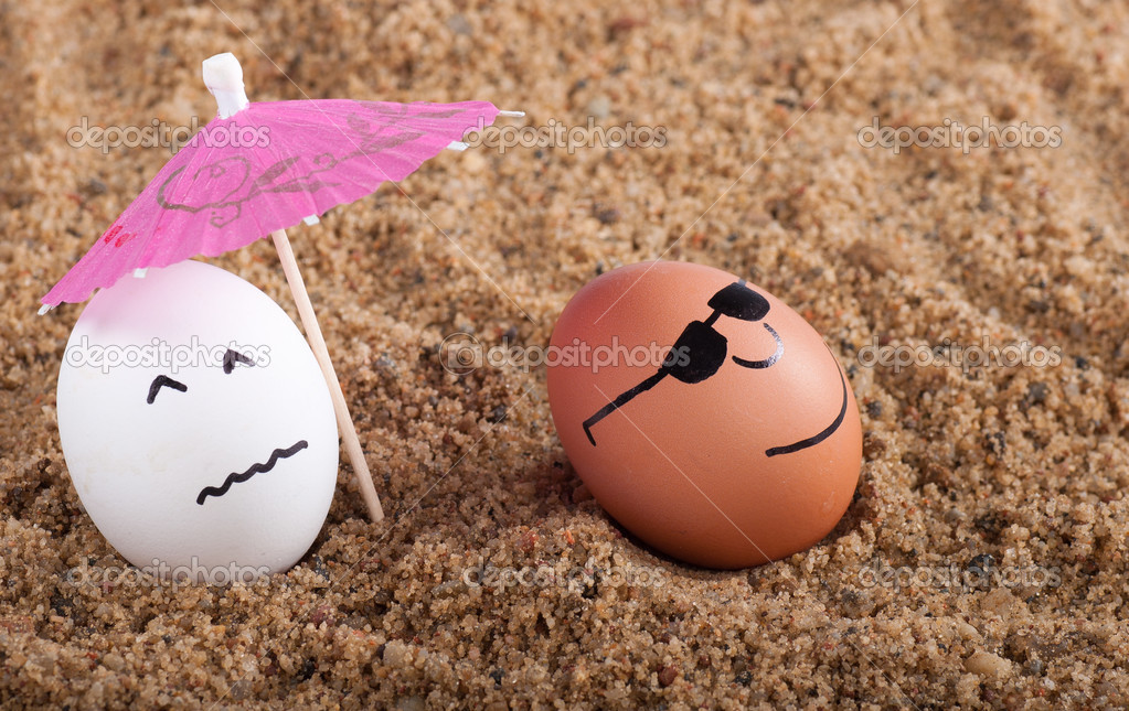 easter funny eggs under umbrella on a sand.